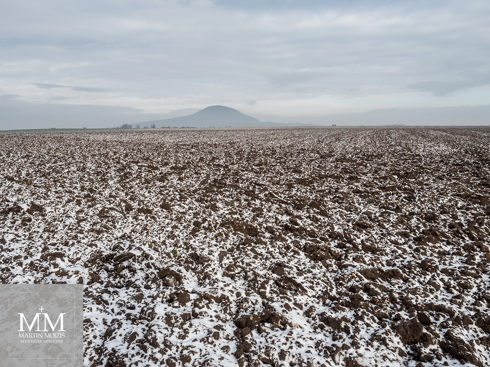 Zimní pole pod horou Říp. Fotografie vytvořena objektivem Olympus 12 - 40 mm 2.8 Pro.